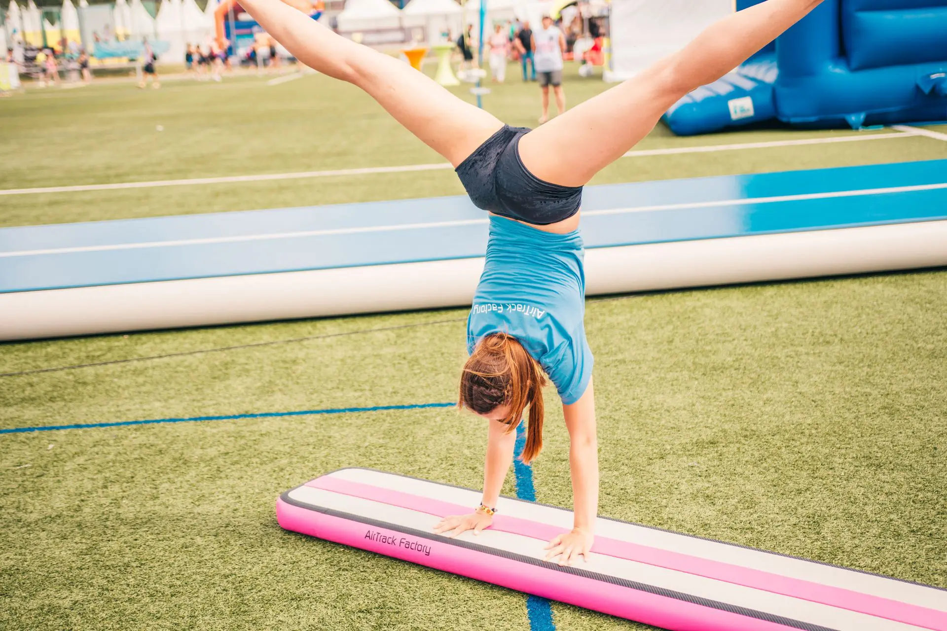 Gymnast tumbling on inflatable balance beam pink