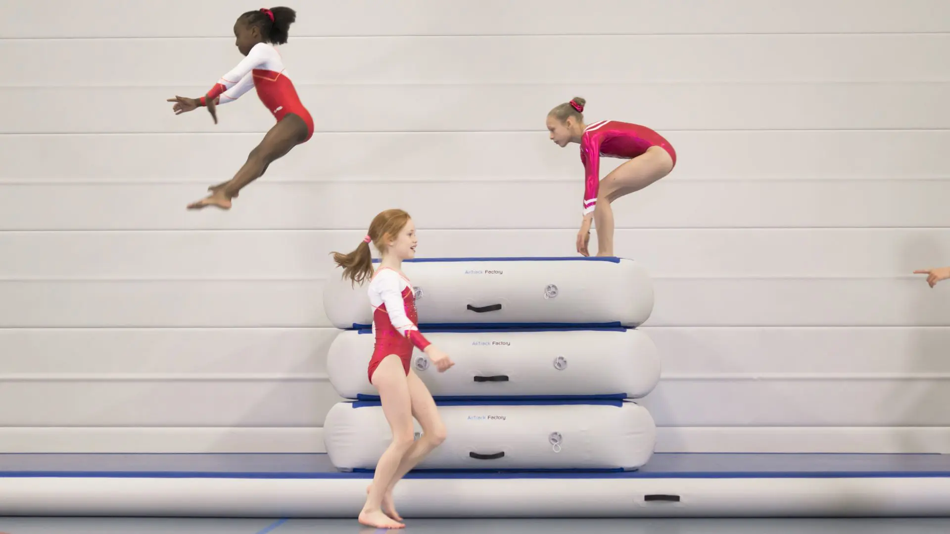 Gymnasts jumping over inflatable vaulting box